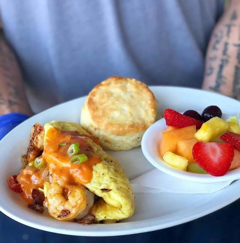 omelet with fresh fruit and a biscuit