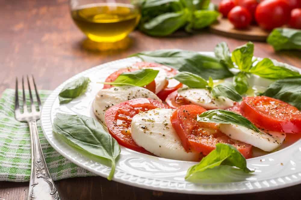 Caprese salad with fresh tomatoes, mozzarella, basil, and olive oil.